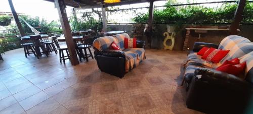 a restaurant with couches and tables and a bar at Hotel Pousada Viking in Jacumã
