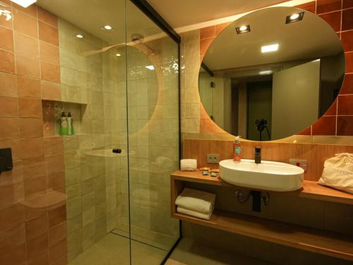 a bathroom with a sink and a shower at Grand Mercure Curitiba Rayon in Curitiba