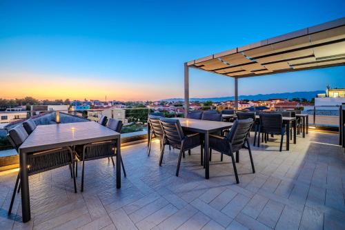 a patio with tables and chairs on a roof at Luxury Apartments VilaMaloca in Vir