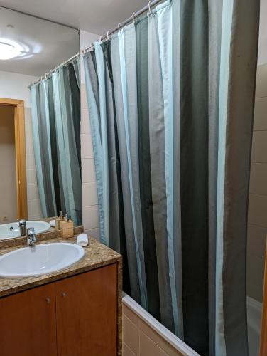 a bathroom with a sink and a shower curtain at Apartment Lisbon Airport in Lisbon