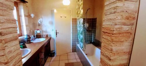 une grande salle de bain avec deux lavabos et une douche dans l'établissement La Chataîgnière, à Saint-Géry