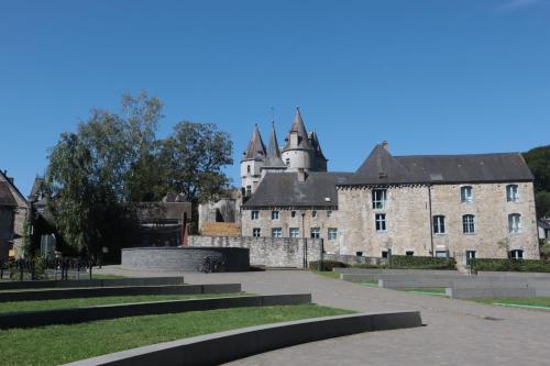 an old stone building with a castle in the background at Sunclass Durbuy Chalet 98 Woody in Durbuy