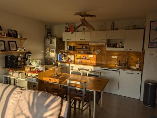Il comprend une cuisine avec une table en bois et un évier. dans l'établissement Aux pieds des dunes, à Labenne