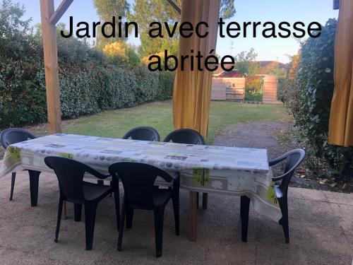 a table with chairs and a table cloth on it at Chambre au coeur du Bassin in Biganos