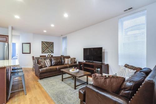 a living room with leather furniture and a flat screen tv at Lincoln Park Living - Suite 1 in Chicago