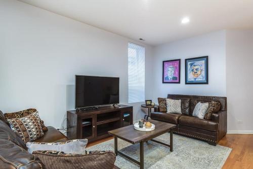 a living room with leather furniture and a flat screen tv at Lincoln Park Living - Suite 1 in Chicago
