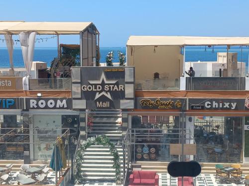 a building with signs on it with the ocean in the background at شقة فندقية على البحر 3 in Hurghada