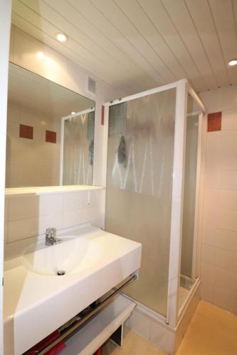 une salle de bain avec un lavabo blanc et un miroir dans l'établissement Résidence Roches Rouges B - Appartement calme et lumineux au pied des pistes. MAE-1714, à Tignes