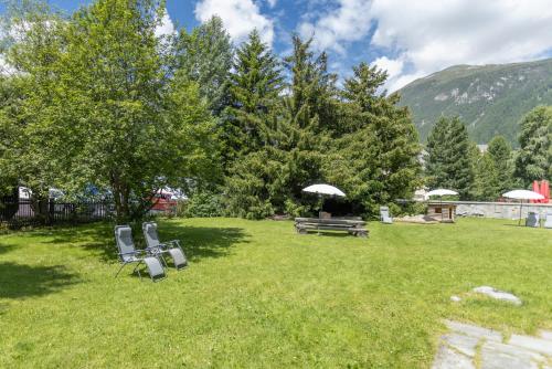 a yard with two chairs and a picnic table at Chesa-Strimer - Studio in La Punt-Chamues-ch