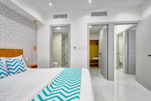a bedroom with a large bed and a bathroom at Monaco Residences Piantini in Santo Domingo
