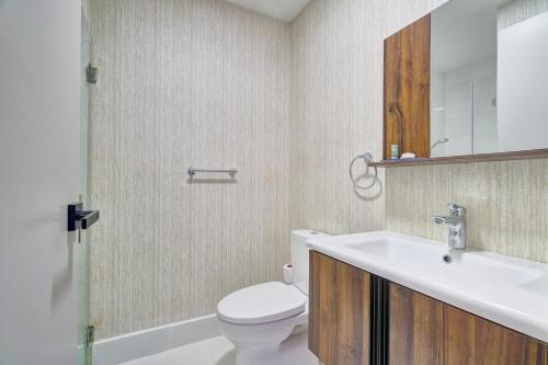 a bathroom with a white toilet and a sink at Monaco Residences Piantini in Santo Domingo