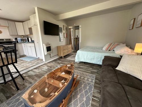 a living room with a wooden boat on the floor at Updated Studio Style room on Lake Huron in Lincoln Junction