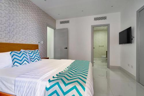 a bedroom with a large bed and a television at Monaco Residences Piantini in Santo Domingo