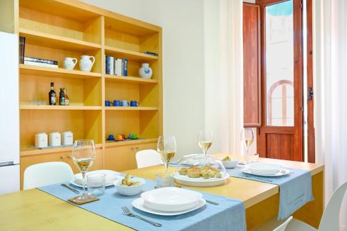 a dining room table with plates and wine glasses at VivIglesias in Iglesias