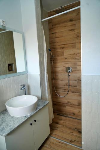 a bathroom with a white sink and a shower at Swiss Apartmani in Banja Luka