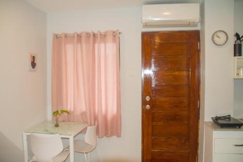 a room with a desk and a table and a door at LL-Apartelle in Lo-oc