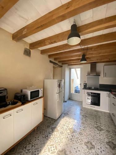 - une cuisine avec des appareils électroménagers blancs dans l'établissement La Maison Bleue, maison mitoyenne de campagne, à Vincelles