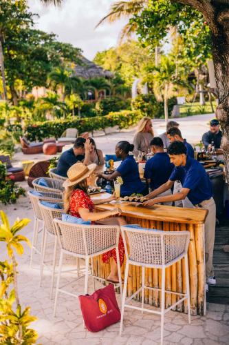 a group of people sitting at tables in a restaurant at Matachica Beach Resort and Spa in San Pedro