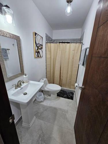 a bathroom with a white sink and a toilet at Casa Angulo 8 Guest Gated Home in Viñedos Del Mar in El Suazal