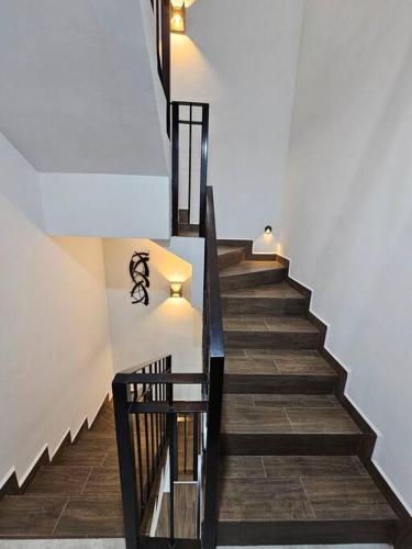 a staircase with black railings and wooden floors at Casa Angulo 8 Guest Gated Home in Viñedos Del Mar in El Suazal