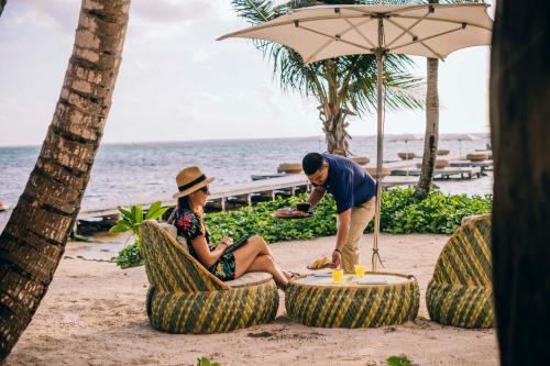 un hombre y una mujer sentados en sillas en la playa en Matachica Beach Resort and Spa, en San Pedro