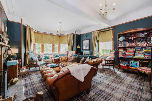 a living room with leather couches and a bookshelf at Whitebridge Hotel in Whitebridge