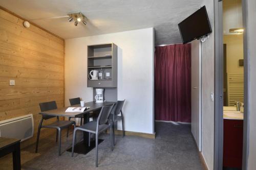 une salle à manger avec une table et des chaises dans l'établissement Résidence Carroley A - Studio pour 4 Personnes 37, à Mâcot La Plagne