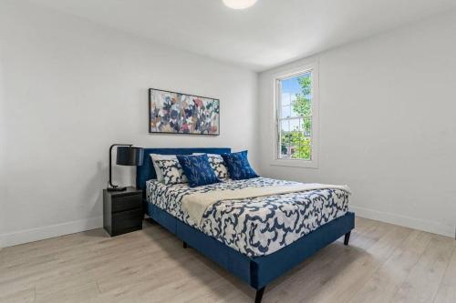 a bedroom with a blue bed and a window at Appartement haut de gamme NDG in Montreal