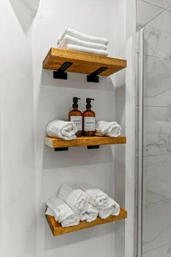 a bathroom with wooden shelves with towels and a shower at Appartement haut de gamme NDG in Montreal