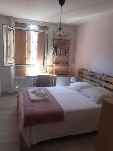 une chambre avec un lit, une table et une fenêtre dans l'établissement Panoramique sur la baie de la ciotat, à La Ciotat