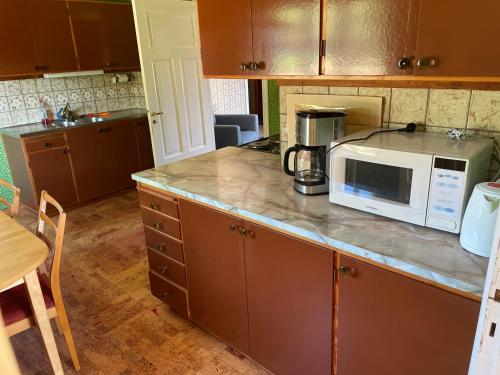 a kitchen with a counter with a microwave on it at Calm and private country side property with own waterfront by large river in Strömmarna