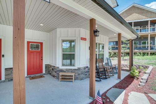 a front porch with a red door and chairs at Hot Tub and EV Charger Helen Getaway with Views! in Helen