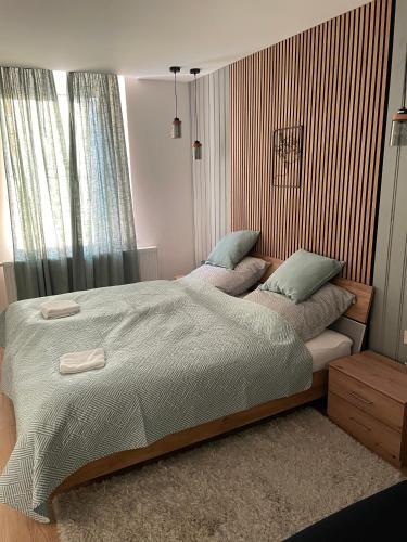 a bed with two pillows on it in a bedroom at Péterfia Boutique Apartments in Debrecen