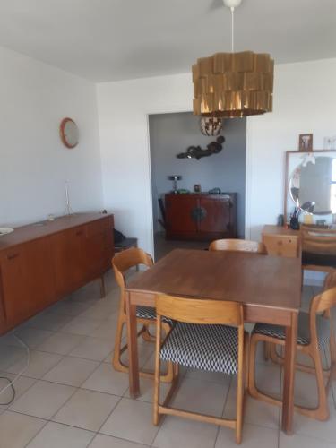 une salle à manger avec une table et des chaises en bois dans l'établissement Panoramique sur la baie de la ciotat, à La Ciotat