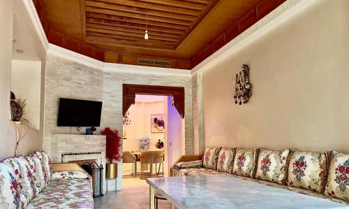 un soggiorno con un divano e un tavolo di Palmeraie 5 Vue Piscine et Jardin a Marrakech