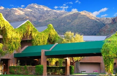 a building with a green awning with mountains in the background at Ventana Canyon Club and Lodge in Tucson