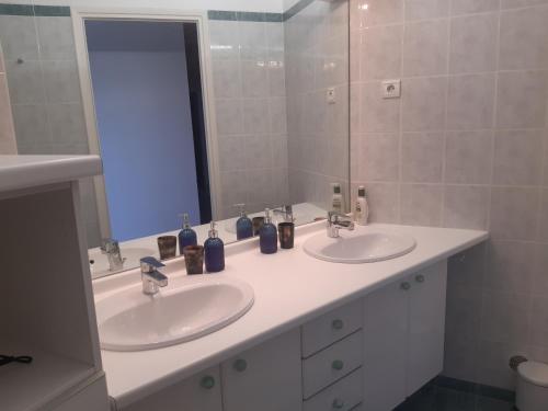 une salle de bain avec deux lavabos et un miroir dans l'établissement Panoramique sur la baie de la ciotat, à La Ciotat