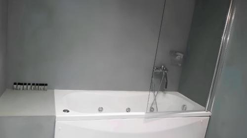 a white bath tub with a shower in a bathroom at ZEN Minimal Luxury Housing Tyros in Tiros