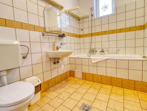 a bathroom with a toilet and a sink at Villa Park Apartmanház in Szilvásvárad