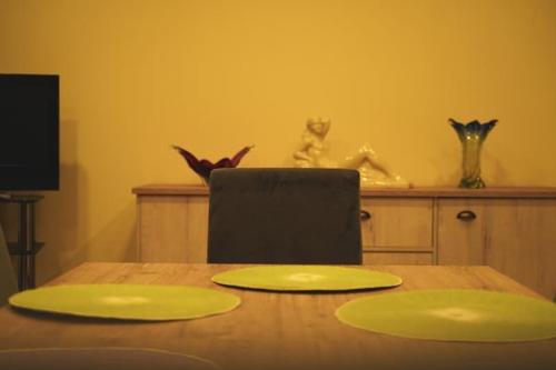 a wooden table with two green plates on top of it at Villa Flaviae in Chaves