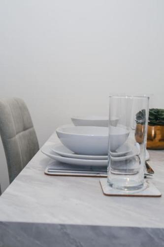 a table with a bowl and a glass on it at Homely 3-bed home Milton Keynes in Simpson