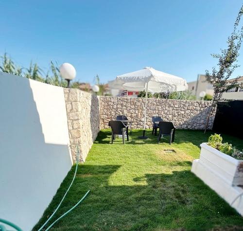 a backyard with chairs and a stone wall at PEDRO NAVARINO VII Laganas in Laganas