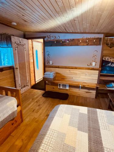 a room with a bed and a wooden wall at Summit River Lodge & Campsites in Valemount