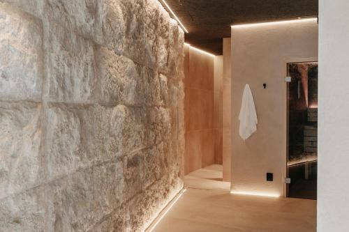 a room with a stone wall and a hallway at Bad Ratzes in Siusi