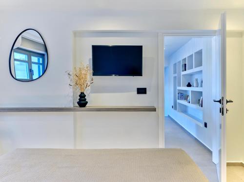 a living room with a tv and a mirror at Villa Sol Este Naousa Paros in Naousa