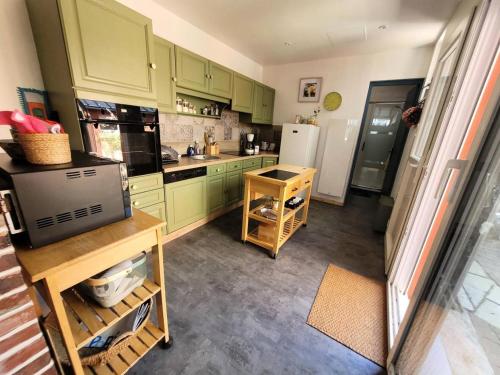 une cuisine avec des armoires vertes et un réfrigérateur blanc dans l'établissement Résidence 743-pleneuf Val Andre - Vos vacances en famille 3 chambres 50 mètres de la mer MAE-7611, à Pléneuf-Val-André