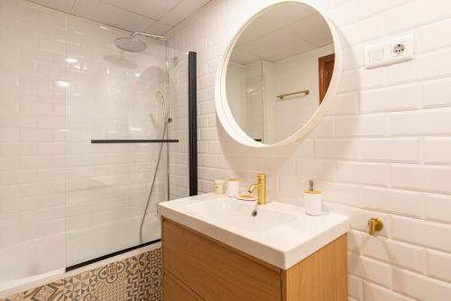 a white bathroom with a sink and a mirror at Apartamento Boho en El Soho de Málaga in Málaga