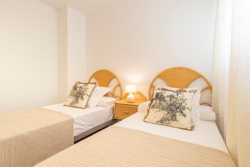 two beds in a small room with two lamps at Apartamento Boho en El Soho de Málaga in Málaga