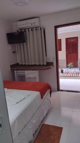 a bedroom with a bed and a sliding glass door at Pousada Villa Goyá in São José da Coroa Grande
