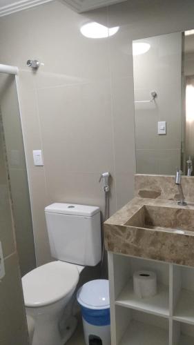 a bathroom with a white toilet and a sink at Pousada Villa Goyá in São José da Coroa Grande